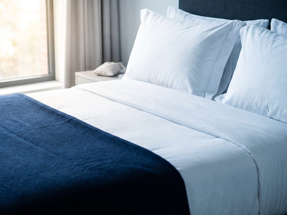 A perfectly made bed with crisp white linens in an Ice Homes serviced apartment
